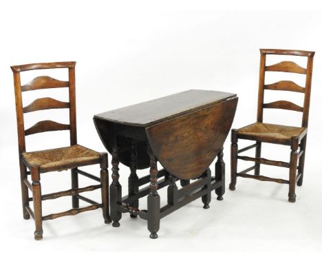 A pair of rush seated ladder back chairs, and a gate leg table