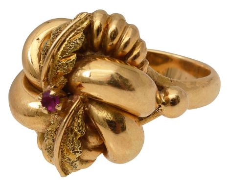 A dress ringdesigned as a flowerhead and foliate cluster with ridged, plain and textured decoration  and set with a ruby to t