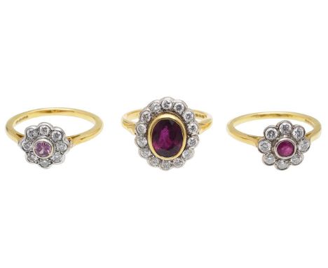 Three 18ct gold, gem-set cluster ringsof varying design, featuring a red to pink centre stone, collet-set above a colourless 