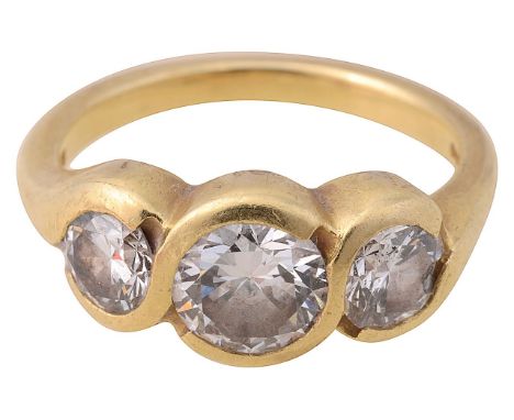 An 18ct diamond three stone graduated ring with round brilliant cut diamonds bezel set to a plain band stamped hallmark to sh