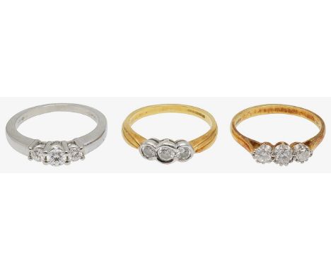 Three diamond-set rings:a three brilliant-cut diamond  and platinum ring, and two three brilliant-cut diamond and 18ct yellow