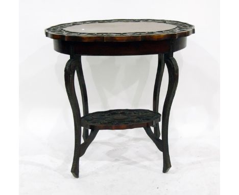 Victorian carved mahogany occasional table, oval with serpentine sides, floral and foliate carved border, under-shelf below, 