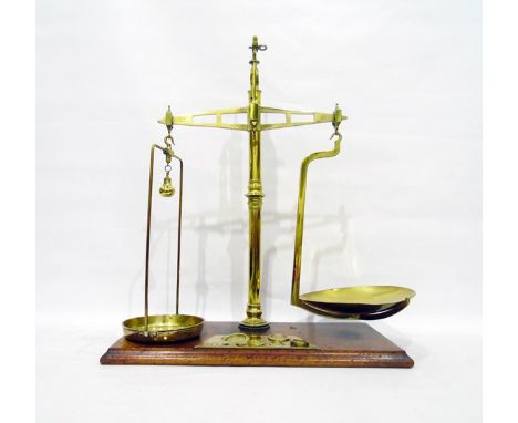 Large pair of brass balance scales by Bartlett of Bristol, on oak base with recessed storage for graduated brass weights 