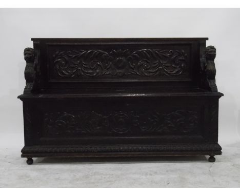 Victorian carved oak renaissance style box seat hall bench, the back with foliate scrolls and having pair winged Gryphon arms