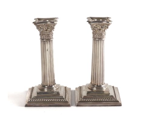 A PAIR OF VICTORIAN SILVER CANDLESTICKSEach designed as a Corinthian column with a detachable sconce, raised on a stepped squ