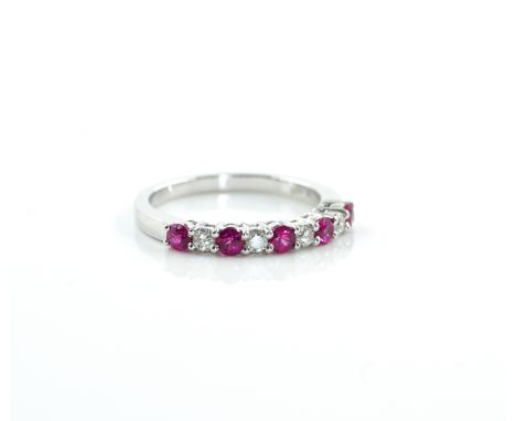 A WHITE GOLD, RUBY AND DIAMOND NINE STONE HALF ETERNITY RINGClaw set with five circular cut rubies, alternating with four cir