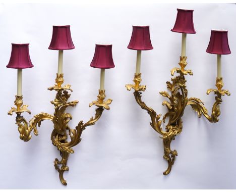A PAIR OF FRENCH LOUIS XV STYLE ORMOLU THREE LIGHT WALL APPLIQUES (2)Late 19th/Early 20th Century 
Each with a foliate backpl