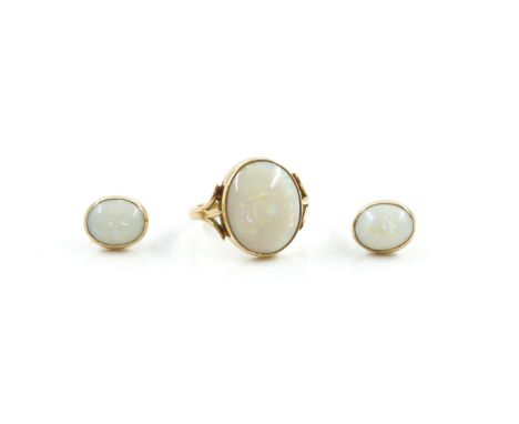 A 9CT GOLD AND OPAL SINGLE STONE RING AND A PAIR OF OPAL SINGLE STONE EARSTUDS (2)The ring collet set with an oval opal betwe