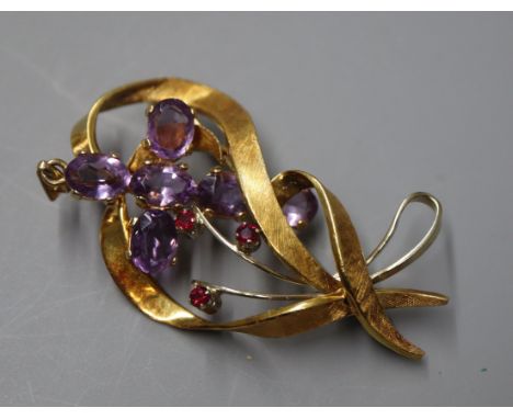 An 18ct white and yellow gold openwork ruby-set ribbon brooch and a 9ct gold and amethyst cross pendant.