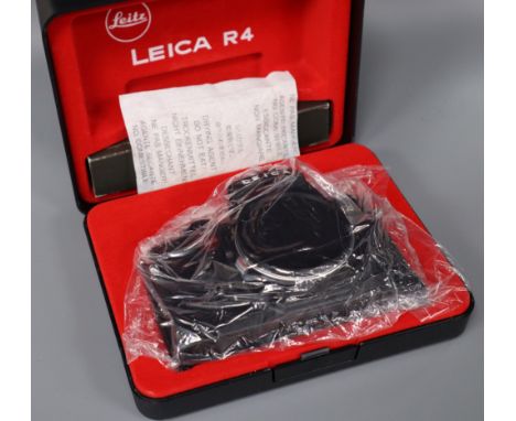 A Leitz black Leica R4 body in presentation box, a Zeiss Ikon Super Ikonta folding bellows camera and sundry accessories incl