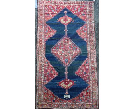 An antique Karabagh carpet, dated 1892, with stepped motifs on a red ground, with three row border, 11ft 9in by 6ft 8in