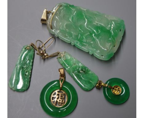 A carved jade pendant of tapered rectangular form, a similar pair of earrings and two jade bi-disc pendants mounted in yellow