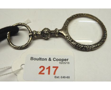 A Magnifying Glass in a chased silver frame and silver ring handle, maker: William Comyns.