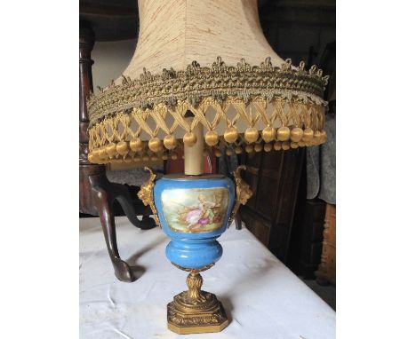 A late 19th century vase column Table Lamp painted with panels of figures and with gilt metal mounts on a square base.