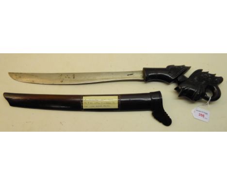 A presentation Malay Short Sword in a carved ebonised wood scabbard.