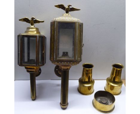 A brass and glass Coach Lamp with eagle finial, a smaller Lamp and three brass shell case Vases.