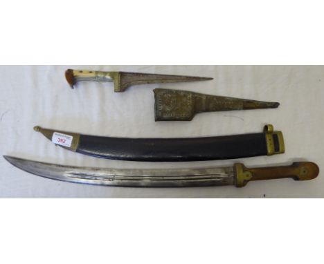 A 19th century Kindjal, possibly Russian, with fullered curved blade and brass mounted scabbard with wooden grip, and an Indo