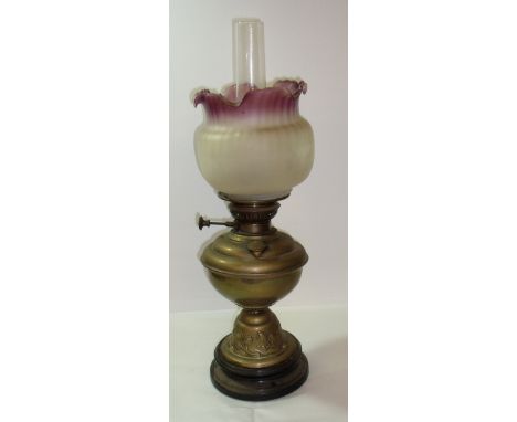 Brass paraffin lamp the body with embossed detail, opaque glass shade and clear glass chimney on stepped base