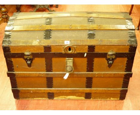 A VINTAGE DOME TOPPED TRAVEL TRUNK with wood and metal banding, leather carry handles marked 'M J', 59.5 cms high, 87 cms wid