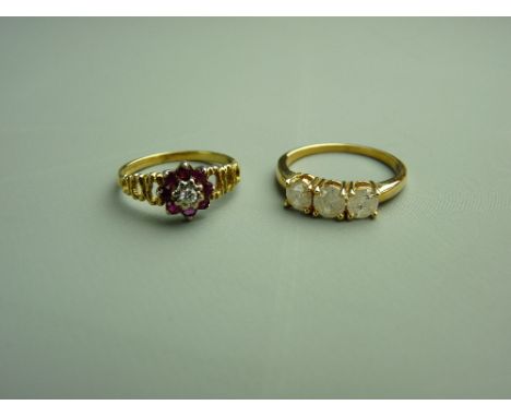 AN EIGHTEEN CARAT GOLD RUBY CLUSTER RING, 2.6 grms and a nine carat gold three stone diamond ring, each stone estimated 0.4 c