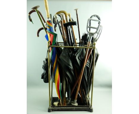 A VINTAGE BRASS & IRON SIX SECTION STICKSTAND and contents to include walking canes, umbrellas, riding crops, shooting sticks