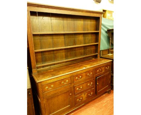 AN ANTIQUE OAK DENBIGHSHIRE STRAIGHT FRONT WELSH DRESSER, the wide boarded three shelf rack with reeded side detail, the base