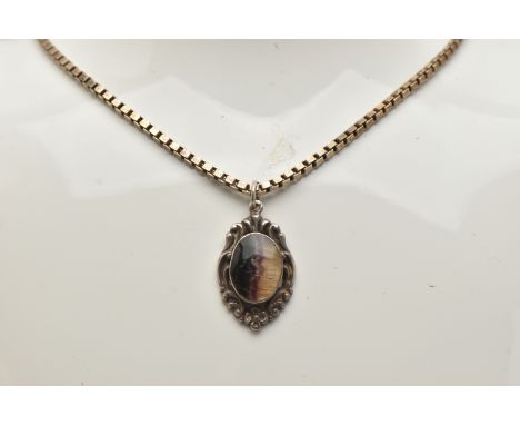 A BLUE JOHN FLOURITE PENDANT WITH SILVER CHAIN, the white metal scrolling detailed pendant set with an oval cut Blue John flu