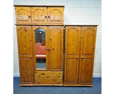 A MODERN PINE TRIPLE DOOR WARDROBE, with a three door section to the top, a central mirrored door, and two drawers, width 127