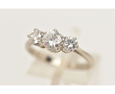 A WHITE AND YELLOW METAL DIAMOND THREE STONE RING, set with graduating round brilliant cut diamonds, the central diamond meas