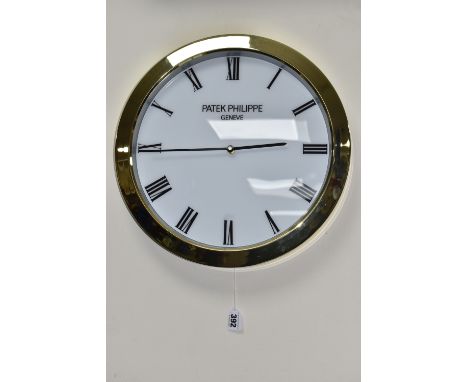 A PATEK PHILIPPE GENEVE DISPLAY CLOCK with printed Roman numeral timestamps on a plain white face and gold coloured metal fra