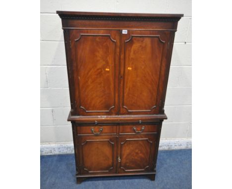 A JAYCEE MAHOGANY DRINKS CABINET, with two sets of double doors, a single drawer, an accessory drawer, and a bushing slide, w