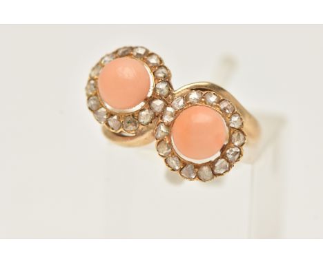 A YELLOW METAL CORAL AND DIAMOND RING, of a cross over design, with two circular clusters each with a central coral cabochon 
