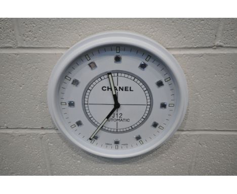 A CHANEL J12 AUTOMATIC DEALERS ADVERTISING WALL CLOCK, with a white frame and face, diameter 35cm (condition report: untested