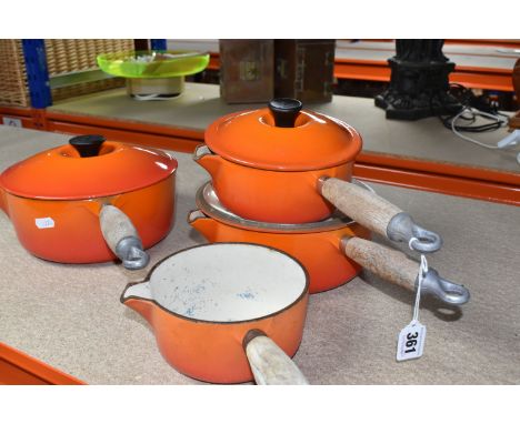 FOUR LE CREUSET CAST IRON SAUCEPANS, in orange enamel with pouring lips and wooden handles, diameters 14cm, 16cm, 20cm and 22