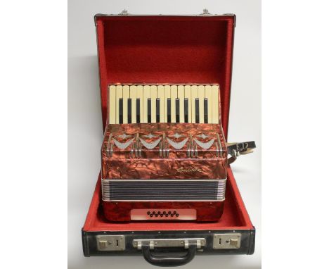A vintage German twelve bass Galotta piano accordion, red marbled finish, in leather carry case.