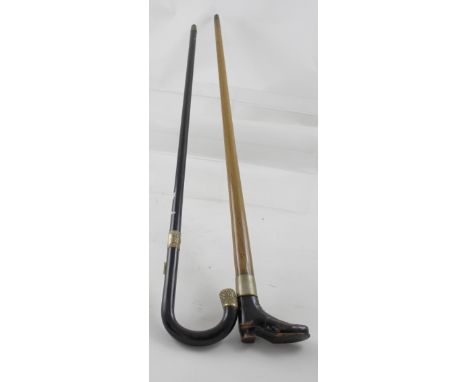 An ebonised walking cane embellished with gold-plated tip and collar and a homemade stick with boot-shaped handle (2).