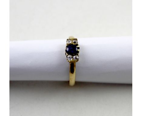 A yellow metal ladies' dress ring, platform set with central sapphire and two white stones to either side, size T, approx 2.6