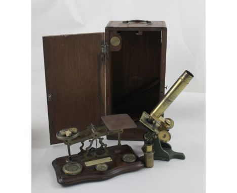 A Victorian brass microscope and lens in wooden case, with a small quantity of slides and a set of brass postal scales and we