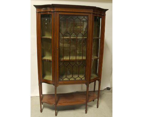 An Edwardian mahogany inlaid display cabinet central astragal glazed doors with serpentine glass to either side, glass panels