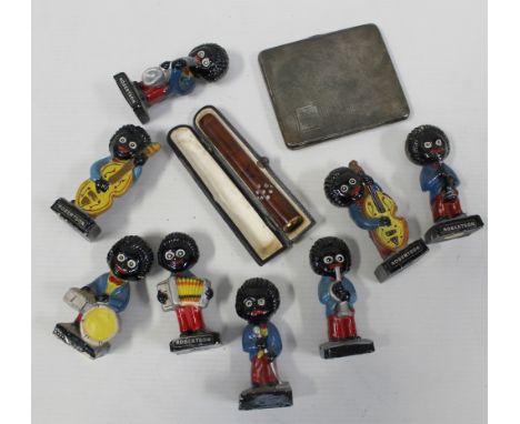 A group of eight Robinson's musician 'Golly' figures, an early 20th century cased amber-effect and yellow metal cheroot holde