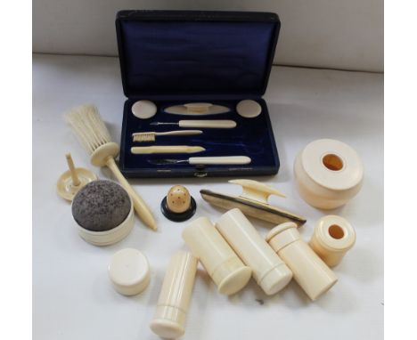 A 1920s carved ivory dressing table set comprising vanity jars, hat pit jar, ring tree, nail buffer etc, also a cased set (la