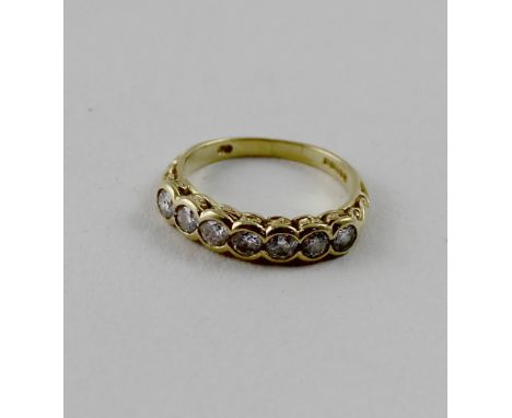 An 18ct yellow gold seven-stone collet-set diamond ring, each stone approx 0.10ct, size I, approx 3.3g.