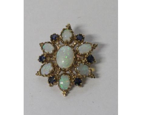 A 9ct yellow gold oval brooch set with seven opals and six sapphires, one central oval cabochon opal with six oval cabochon o