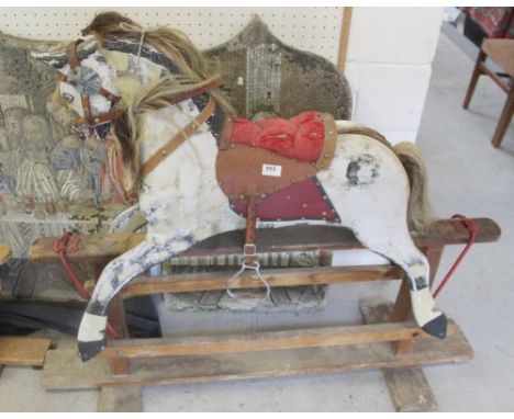 A vintage dapple grey painted rocking horse with red saddle and brown mane, length 204cm, height 104cm.