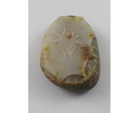 A jadeite boulder with carved detail of a spider, length 6cm.