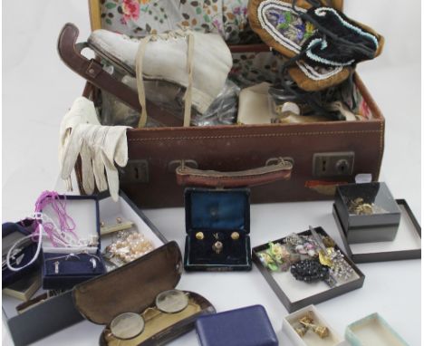 A vintage brown leather suitcase with cotton floral lining containing a quantity of vintage costume jewellery to include broo