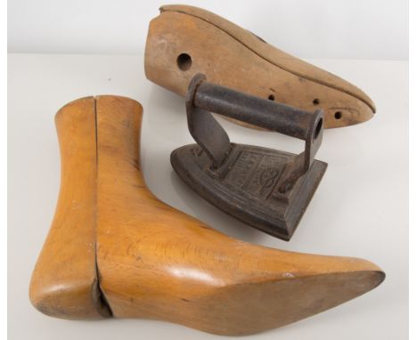 Box of early wooden shoe trees, tools and cast iron flat irons.