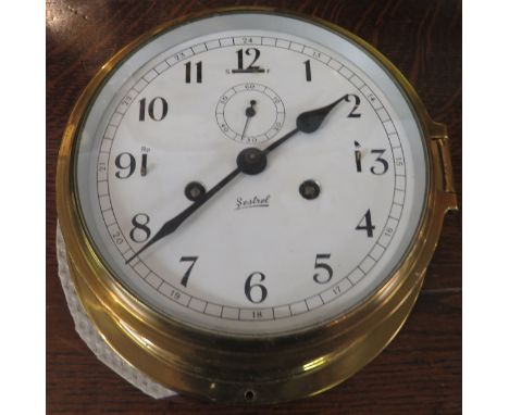 A brass framed circular striking marine clock by Sestrel on a white dial with an Arabic five minute chapter with hinged brass