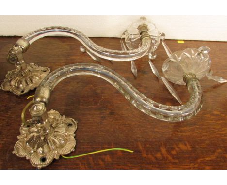 A pair of electric wall light fittings, each with moulded electroplated bracket and single glass serpentine arm with small pe