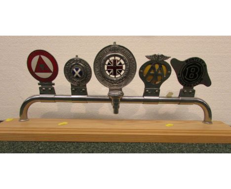 Five car badges mounted on a chromium bar and set on a pine plinth - Institute of Advanced Motorists, Royal Scottish Automobi